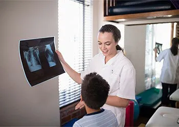 A doctor consulting with a pediatric patient about his x-rays