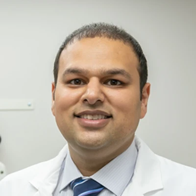 A headshot photo of Dr. Maan Dhanjal, a chiropractor at Maan Chiropractic